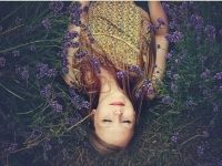 organic hydrotherm facial lady laying down in the fields of lavender with her eyes closed